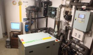 a machine in a room with pipes and a monitor